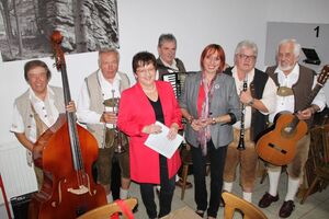 Jutta Deiml und Brigitte Scharf zwischen der Falkenberger Zoiglmusik